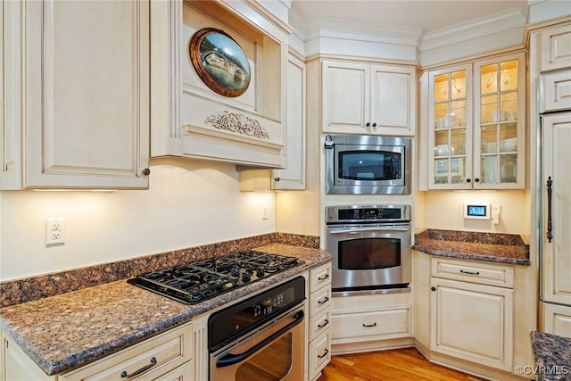 9929 Eildonway Pl, Henrico, VA 23238 - kitchen featuring appliances with stainless steel finishes, premium range hood, glass insert cabinets, dark stone countertops, and ornamental molding