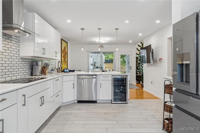 8256 Greystone W Cir, Henrico, VA 23229 - kitchen featuring wine cooler, stainless steel appliances, wall chimney exhaust hood, backsplash, and white cabinetry
