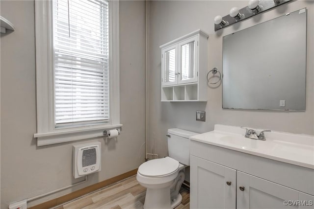 1320 W Main St, Richmond, VA 23220 - half bath featuring vanity, healthy amount of natural light, heating unit, and wood finished floors