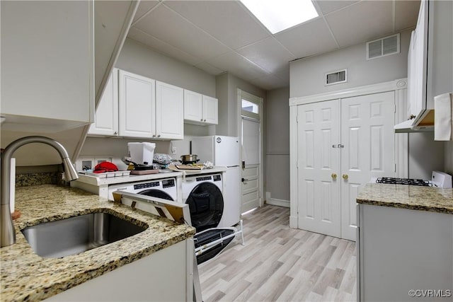 1320 W Main St, Richmond, VA 23220 - kitchen with white cabinets, light wood-style flooring, light stone countertops, and a paneled ceiling
