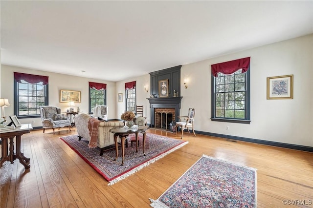 88 Holly Grv, Jamestown, VA 23185 - living room with healthy amount of natural light, a brick fireplace, and hardwood / wood-style flooring
