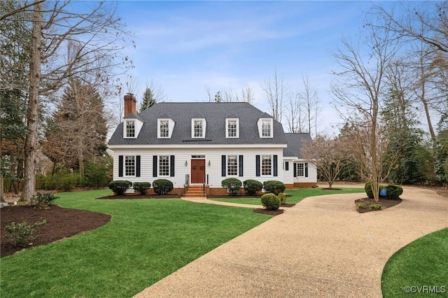 88 Holly Grv, Jamestown, VA 23185 - new england style home featuring a chimney, roof with shingles, a front lawn, and driveway