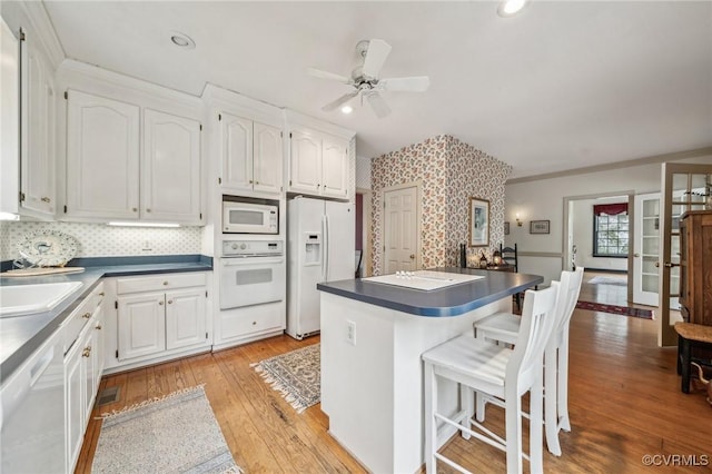 88 Holly Grv, Jamestown, VA 23185 - kitchen with white appliances, white cabinetry, dark countertops, light wood-type flooring, and recessed lighting