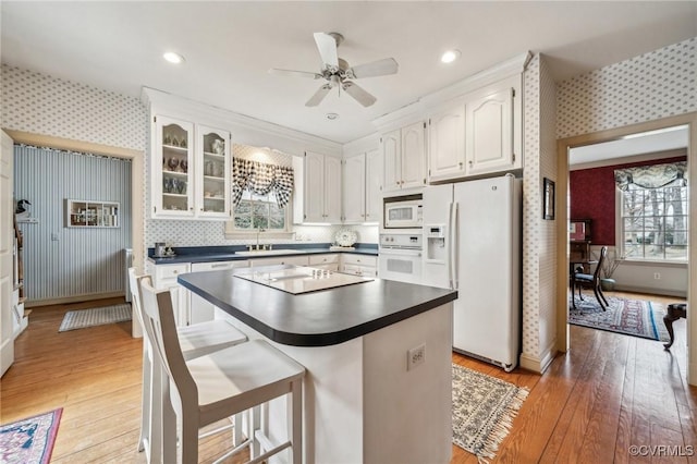 88 Holly Grv, Jamestown, VA 23185 - kitchen with white appliances, wallpapered walls, dark countertops, white cabinetry, and plenty of natural light
