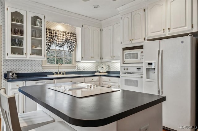 88 Holly Grv, Jamestown, VA 23185 - kitchen featuring white appliances, dark countertops, white cabinets, glass insert cabinets, and crown molding