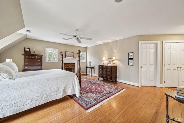 88 Holly Grv, Jamestown, VA 23185 - bedroom featuring light wood-type flooring, a ceiling fan, and a brick fireplace