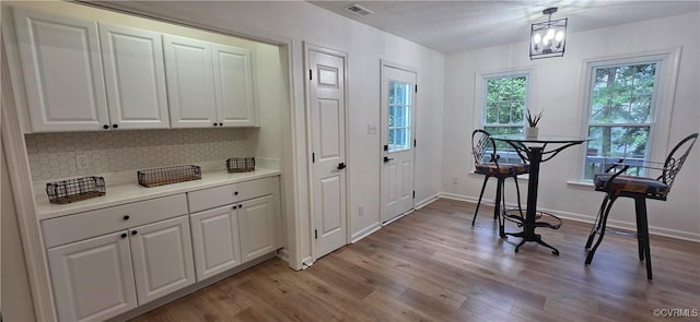 7464 Dutch Lily Ct, Mechanicsville, VA 23111 - dining space with light wood-style flooring, a chandelier, and a textured ceiling