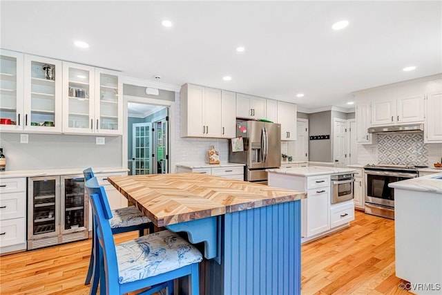 13904 Sunrise Bluff Rd, Chesterfield, VA 23112 - kitchen featuring wine cooler, a kitchen island, stainless steel appliances, crown molding, and white cabinetry