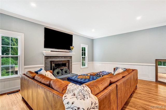 13904 Sunrise Bluff Rd, Chesterfield, VA 23112 - living room featuring wainscoting, light wood-type flooring, crown molding, a fireplace with raised hearth, and recessed lighting