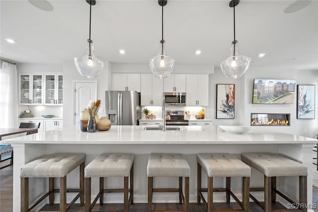 13213 Garland Ln, Midlothian, VA 23114 - kitchen featuring stainless steel appliances, white cabinetry, light countertops, recessed lighting, and glass insert cabinets