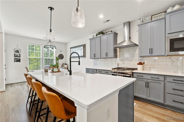 18517 Palisades Rdg, Moseley, VA 23120 - kitchen featuring wall chimney exhaust hood, gray cabinets, stainless steel microwave, and decorative backsplash