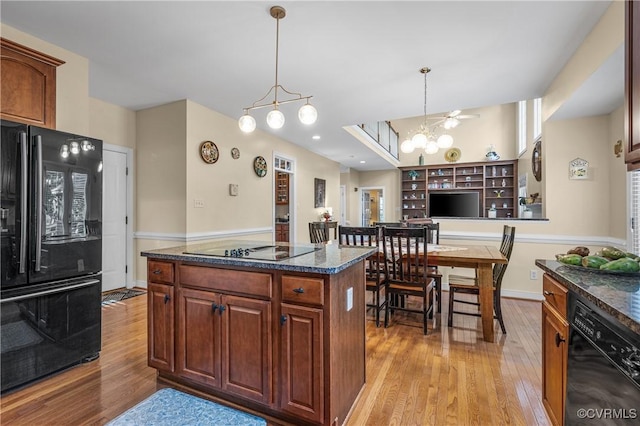 3541 Kings Farm Dr, Midlothian, VA 23113 - kitchen featuring black appliances, light wood-type flooring, decorative light fixtures, a center island, and a chandelier