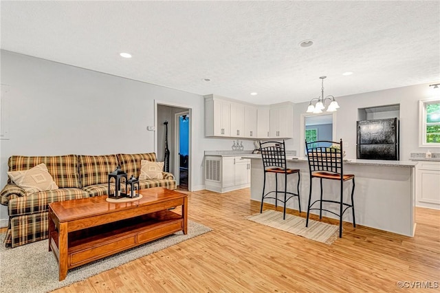 9118 Epps Rd, Mechanicsville, VA 23111 - living area featuring light wood-style flooring, a chandelier, recessed lighting, and a textured ceiling