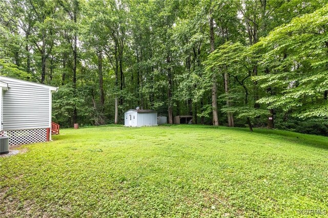 9118 Epps Rd, Mechanicsville, VA 23111 - view of green lawn featuring a storage unit and a wooded view