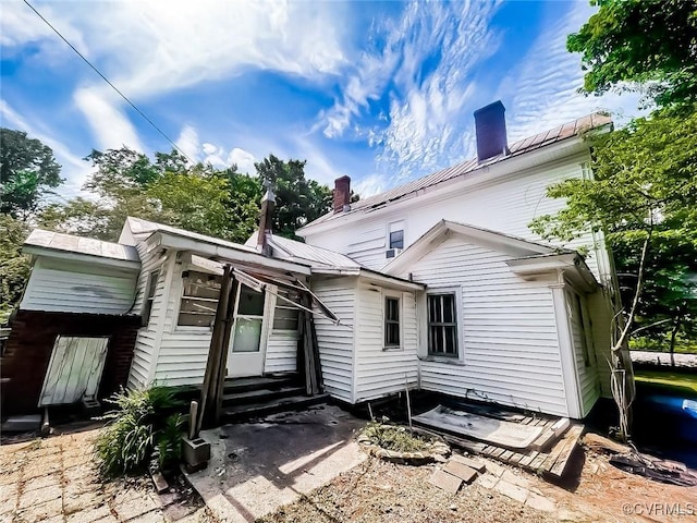 22446 E Depot St, Newsoms, VA 23874 - rear view of property featuring a chimney, entry steps, and a metal roof