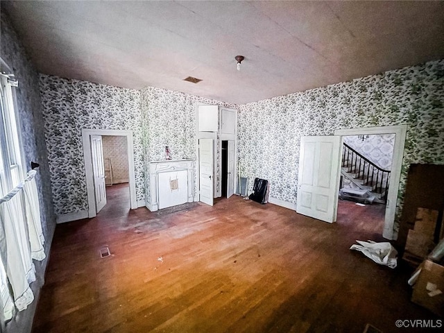22446 E Depot St, Newsoms, VA 23874 - unfurnished living room with wallpapered walls, wood finished floors, and stairway