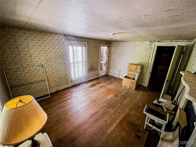 22446 E Depot St, Newsoms, VA 23874 - unfurnished living room featuring wood finished floors, a textured ceiling, and wallpapered walls