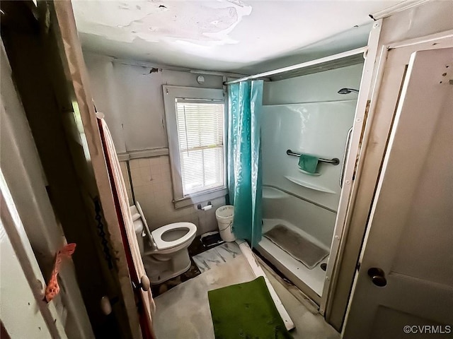 22446 E Depot St, Newsoms, VA 23874 - bathroom with a stall shower, tile walls, marble look tiles, and a wainscoted wall