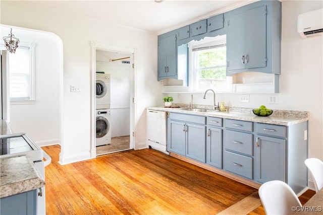 2711 Maplewood Rd, Henrico, VA 23228 - kitchen with white appliances, blue cabinetry, a wall unit AC, stacked washing machine and dryer, and light countertops