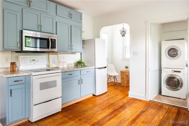 2711 Maplewood Rd, Henrico, VA 23228 - kitchen with white appliances, blue cabinetry, stacked washer and clothes dryer, and light wood-type flooring
