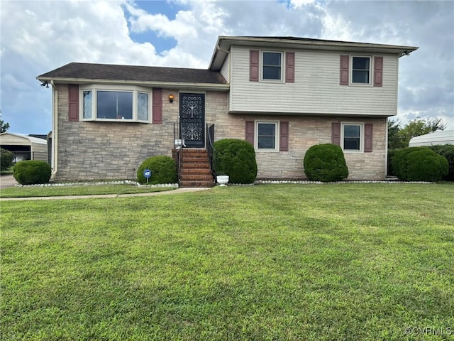 split level home featuring stone siding, a front yard, and a carport