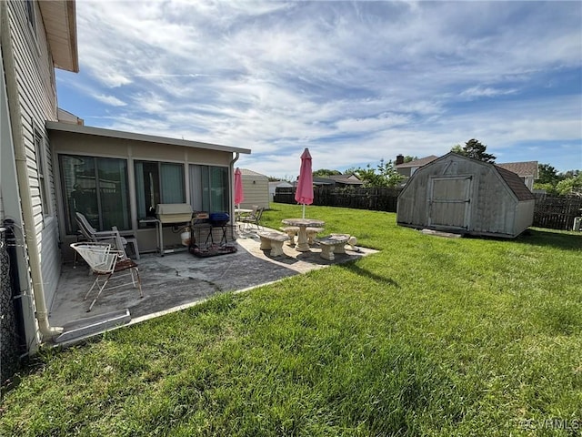 fenced backyard featuring a shed and a patio