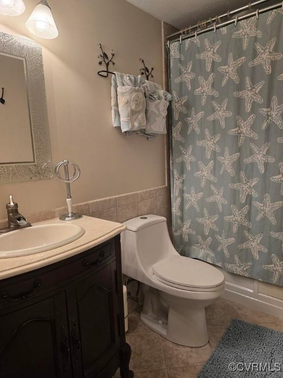 10818 Sebring Dr, Henrico, VA 23233 - full bathroom featuring tile patterned floors, vanity, a shower with curtain, tile walls, and wainscoting