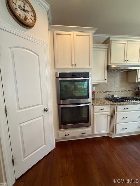 17037 Windon Ct, Moseley, VA 23120 - kitchen featuring appliances with stainless steel finishes, dark wood-type flooring, backsplash, under cabinet range hood, and light stone counters