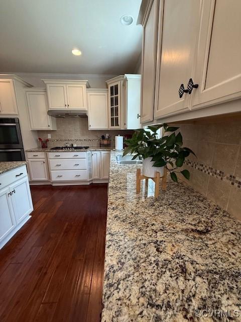 17037 Windon Ct, Moseley, VA 23120 - kitchen featuring backsplash, light stone countertops, glass insert cabinets, stainless steel gas stovetop, and under cabinet range hood