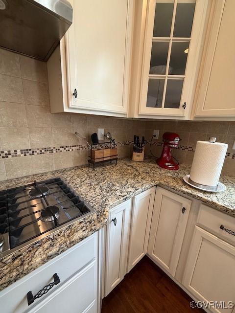17037 Windon Ct, Moseley, VA 23120 - kitchen with ventilation hood, stainless steel gas stovetop, decorative backsplash, glass insert cabinets, and light stone counters