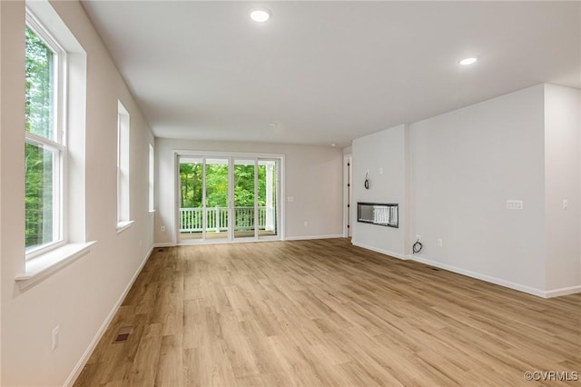 7082 Braxton Ct, Ladysmith, VA 22546 - unfurnished living room featuring healthy amount of natural light, light wood finished floors, and recessed lighting