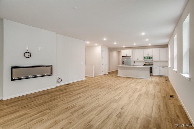 7082 Braxton Ct, Ladysmith, VA 22546 - unfurnished living room with light wood finished floors and recessed lighting