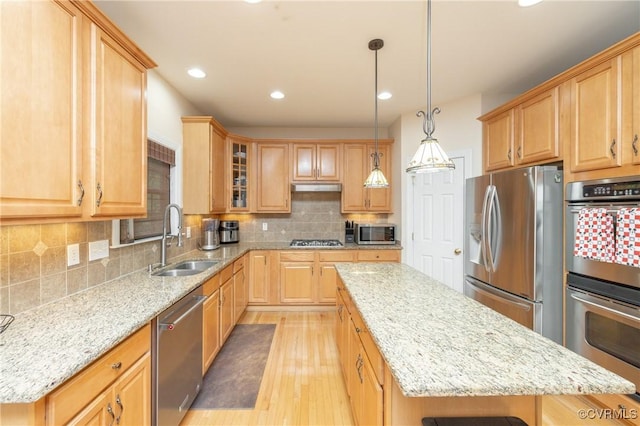 4837 Glenmorgan Ct, Chester, VA 23831 - kitchen with appliances with stainless steel finishes, a kitchen island, light wood-type flooring, light stone countertops, and decorative backsplash