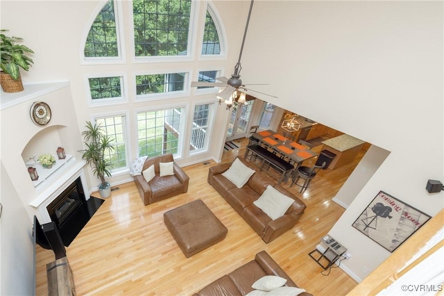 4837 Glenmorgan Ct, Chester, VA 23831 - living area with a high ceiling, wood finished floors, ceiling fan, and a fireplace with flush hearth