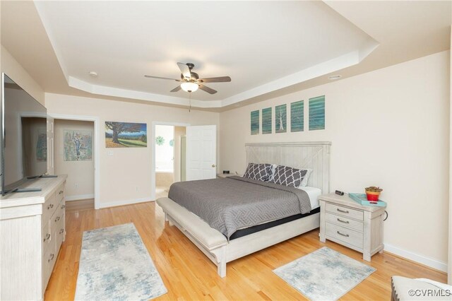 4837 Glenmorgan Ct, Chester, VA 23831 - bedroom with a tray ceiling, light wood-style flooring, a ceiling fan, and connected bathroom