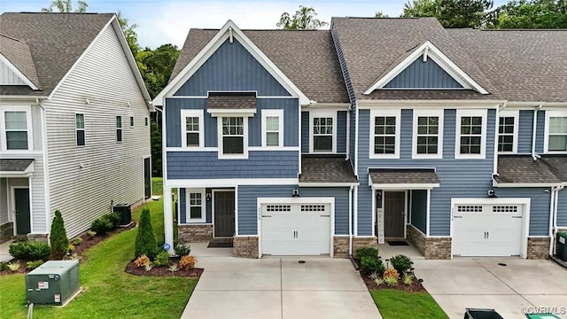 7750 Leeds Castle Ln, New Kent, VA 23124 - craftsman-style house featuring board and batten siding, a garage, concrete driveway, roof with shingles, and a front lawn