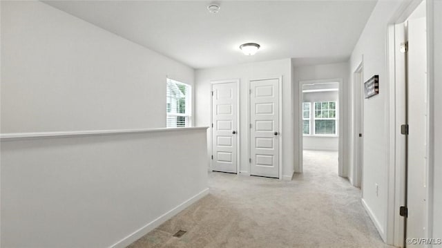 7750 Leeds Castle Ln, New Kent, VA 23124 - corridor with healthy amount of natural light, light colored carpet, and an upstairs landing