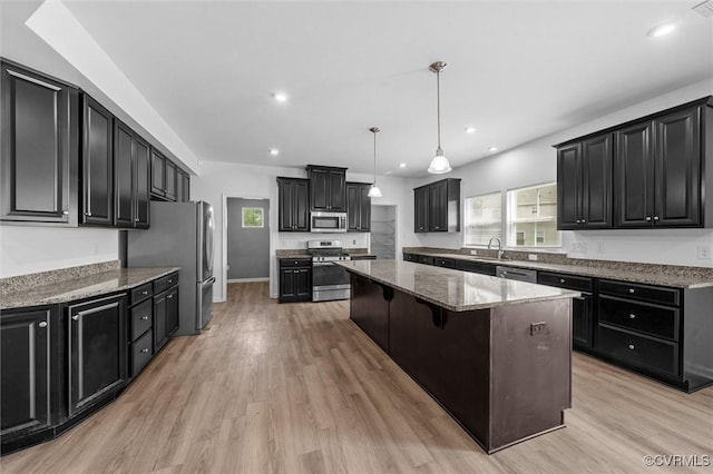10485 Eagle Ct, Prince George, VA 23860 - kitchen featuring stainless steel appliances, a kitchen island, dark cabinetry, light stone countertops, and light wood-style flooring