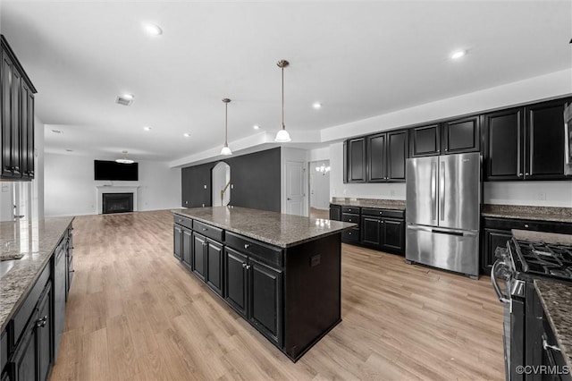 10485 Eagle Ct, Prince George, VA 23860 - kitchen with appliances with stainless steel finishes, dark cabinetry, a kitchen island, light wood-style floors, and open floor plan