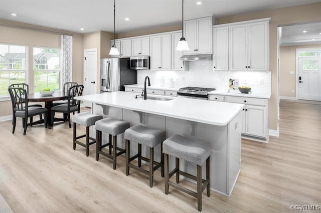 7501 Indian River Run, Henrico, VA 23231 - kitchen featuring appliances with stainless steel finishes, recessed lighting, a breakfast bar, light wood finished floors, and tasteful backsplash