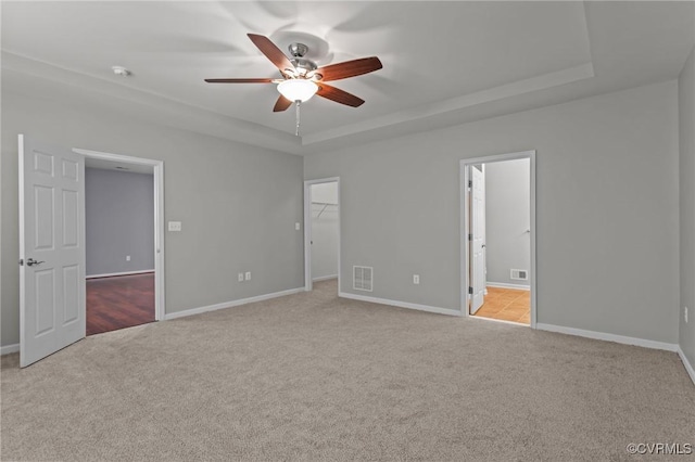 8334 E Lord Botetourt Loop, New Kent, VA 23124 - unfurnished bedroom with carpet, a tray ceiling, a walk in closet, ensuite bathroom, and ceiling fan