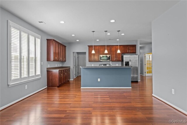 8334 E Lord Botetourt Loop, New Kent, VA 23124 - kitchen with stainless steel appliances, recessed lighting, dark wood-type flooring, hanging light fixtures, and an island with sink