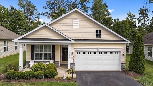 8334 E Lord Botetourt Loop, New Kent, VA 23124 - view of front of home with covered porch, asphalt driveway, an attached garage, stone siding, and a front yard