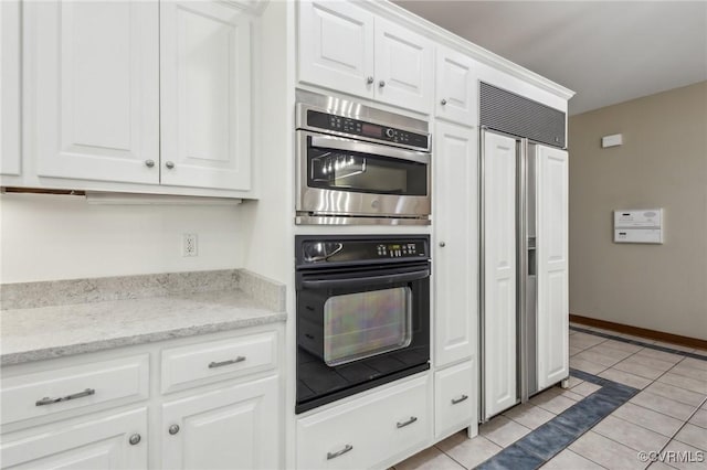 6002 Prospectors Bluff Ln, Mechanicsville, VA 23116 - kitchen featuring paneled built in fridge, stainless steel double oven, light tile patterned floors, and white cabinets