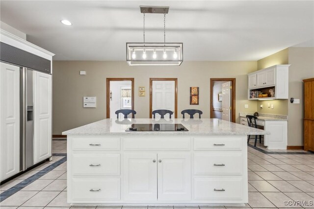 6002 Prospectors Bluff Ln, Mechanicsville, VA 23116 - kitchen with black electric stovetop, light tile patterned flooring, a center island, white cabinetry, and recessed lighting