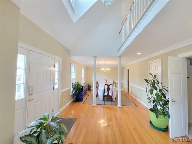 231 White Sand Ct, Colonial Heights, VA 23834 - entryway featuring ornate columns, light wood finished floors, crown molding, high vaulted ceiling, and a chandelier
