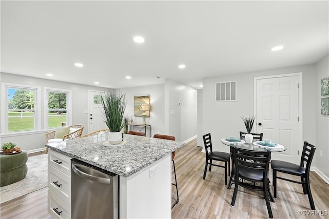 22805 Carson Rd, Carson, VA 23841 - kitchen featuring stainless steel dishwasher, a kitchen bar, white cabinets, recessed lighting, and light wood-style floors