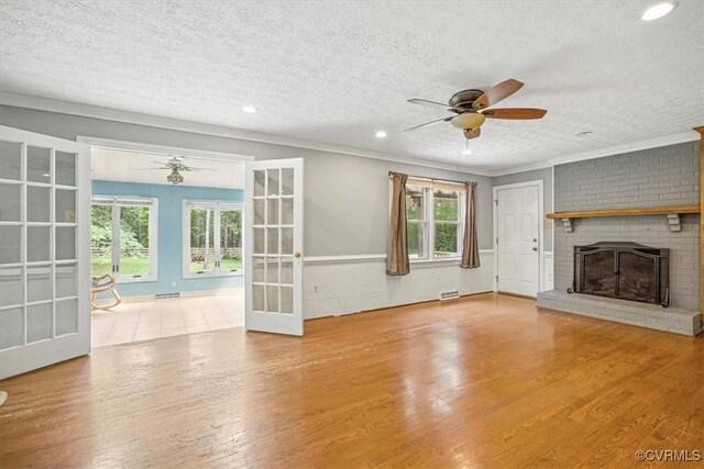 13241 Bailey Bridge Rd, North Chesterfield, VA 23112 - unfurnished living room featuring a ceiling fan, french doors, wood finished floors, a brick fireplace, and a textured ceiling