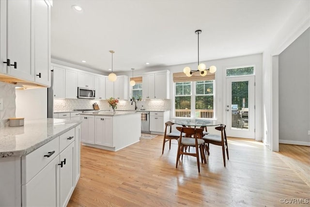 1450 Palmore Rd, Powhatan, VA 23139 - kitchen featuring stainless steel appliances, white cabinetry, decorative backsplash, a chandelier, and light stone countertops