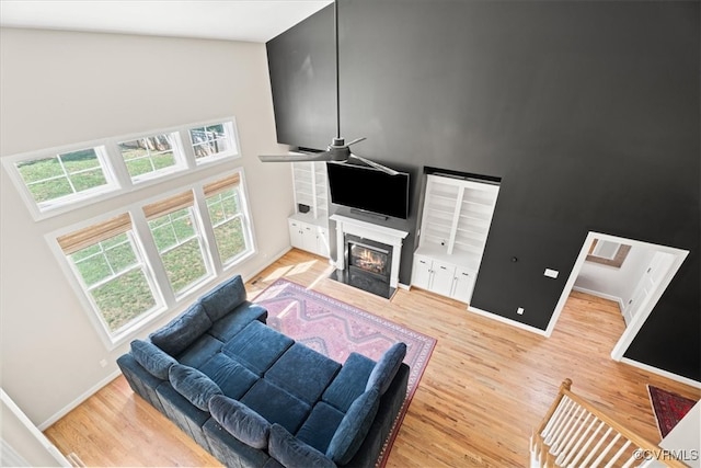 1450 Palmore Rd, Powhatan, VA 23139 - living area featuring ceiling fan, wood finished floors, a fireplace with flush hearth, and a towering ceiling